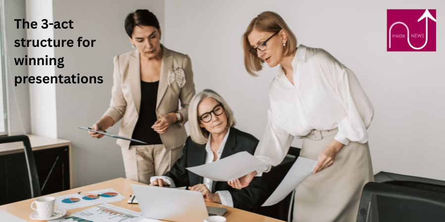 Three ladies looking at papers next to laptop